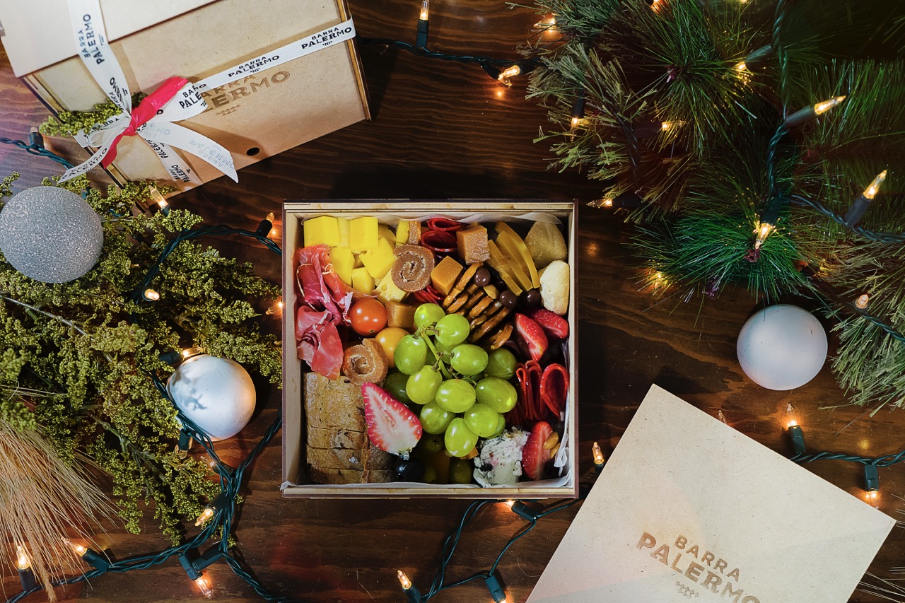 Holiday charcuterie tray with strawberries, grapes, cheeses, and cold cuts presented in wicker basket
