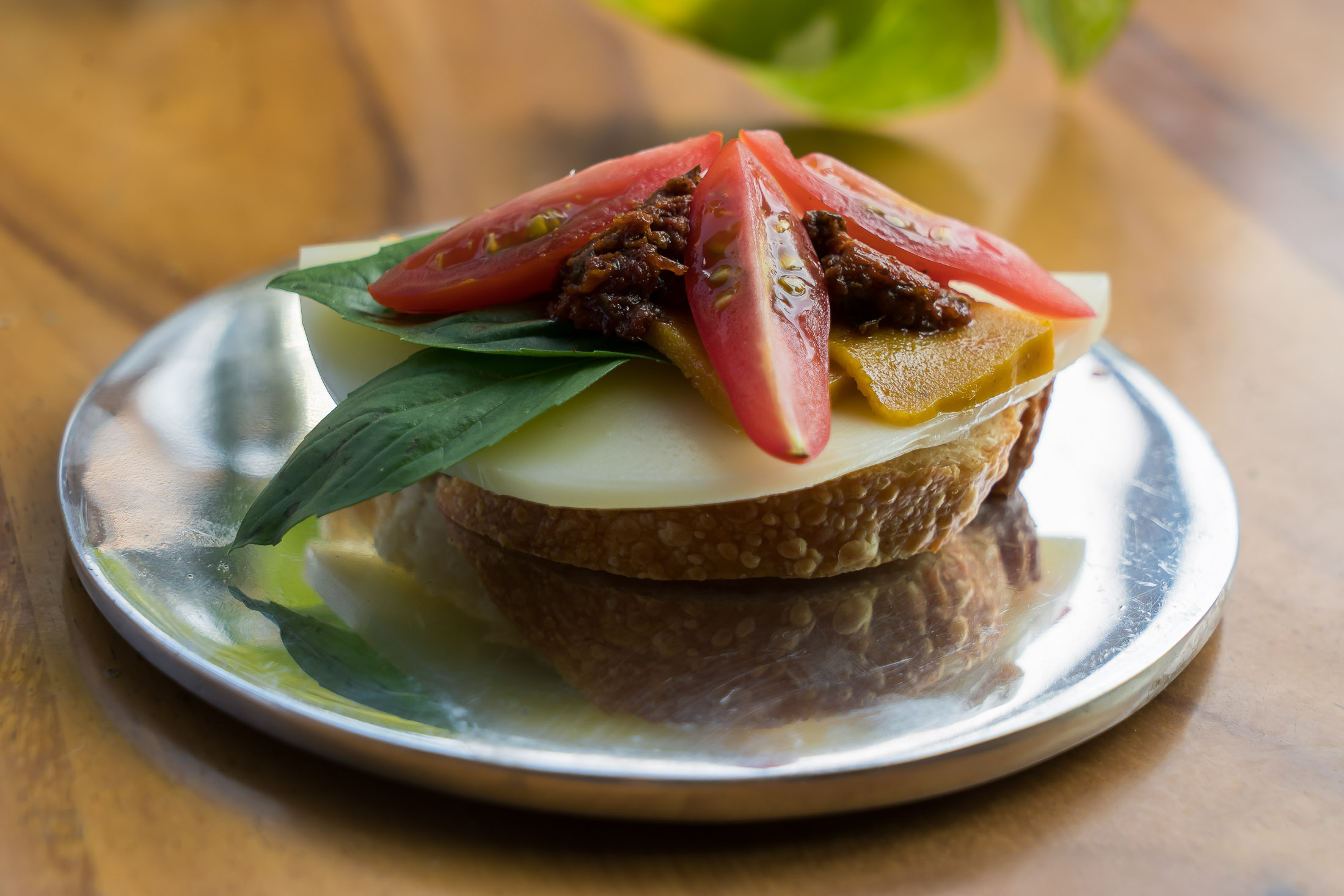 Savory tapas with cheese, tomato, and fresh basil served outdoors in rustic setting